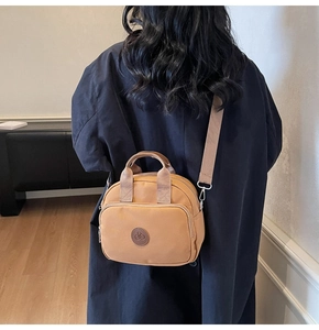 Detail of camel nylon crossbody bag shown from behind to highlight daily style and size