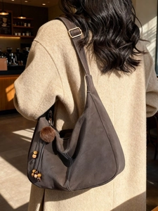 Vintage dark brown hobo tote bag in suede with decorative stitching and fur ball charm