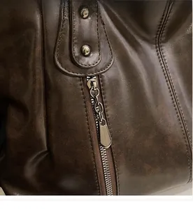 Gros plan du sac en cuir marron vintage avec fermeture éclair fluide et rivets