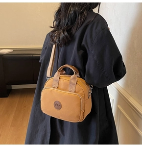 Rear view of model wearing a bright yellow nylon crossbody bag with adjustable strap