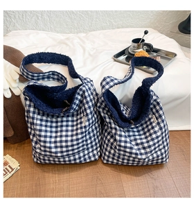 Close-up of blue plaid tote bag with faux shearling lining and stylish cloth label detail