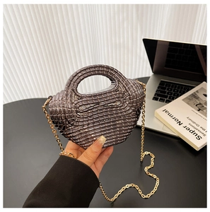 Dettaglio della borsa mini intrecciata grigio scuro con elegante catena dorata
