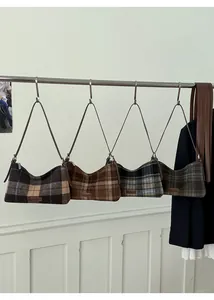 Detailed view of four retro plaid hobo bags with leather straps in various colors