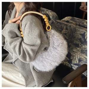 Détail du sac en fausse fourrure avec perles en bois et une bandoulière en perles