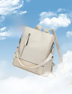 Detail of cream backpack with woven texture and rabbit logo against a sky background