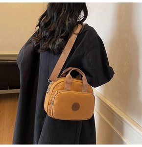 Close-up of ginger yellow canvas crossbody bag with adjustable wide fabric strap