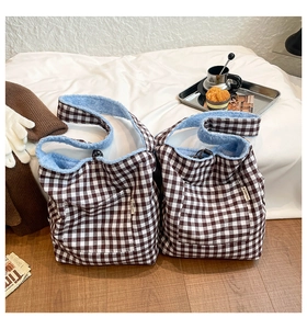 Detail of plaid fleece tote bag with blue faux shearling lining and front pocket
