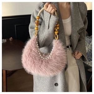 Détail du sac croissant en fausse fourrure rose avec anse en perles de bois et nacre