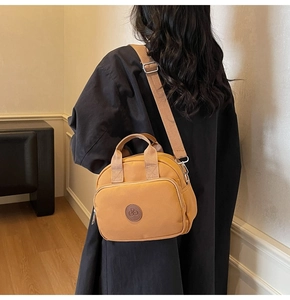 Detail of ginger canvas crossbody bag with adjustable wide strap and front zipper pocket