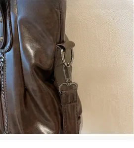Détail du sac en cuir marron vintage avec anneau en D et crochet de sangle en métal nickel noir
