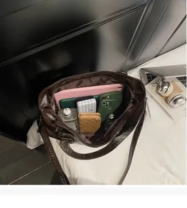 Vue de dessus d'un grand sac cabas en cuir marron avec tablette et accessoires