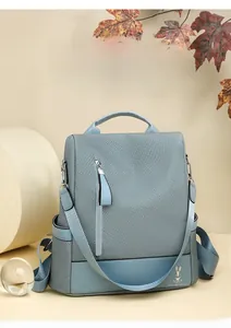 Detail of blue fabric backpack featuring embroidery rabbit logo and leather texture
