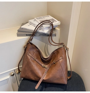 Macro shot of brown leather tote bag with gold ring buckle and adjustable strap