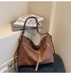 Detailed macro view of dark brown faux leather tote bag with metallic buckle and texture