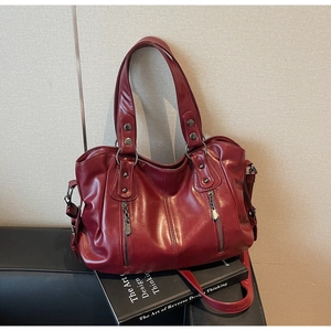 Détail du sac cabas bordeaux en similicuir avec fermetures éclair et rivets métalliques