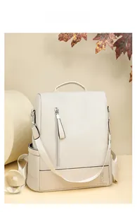 Close-up of beige woven backpack with rabbit logo, leather trim and wide fabric strap