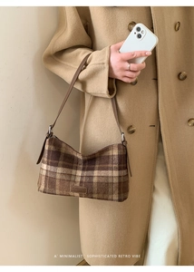 Détail du sac à bandoulière à carreaux marron avec bandoulière en cuir sur manteau d'hiver