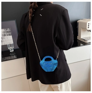 Dettaglio mini borsa in paillettes blu acceso con sottile tracolla a catena in metallo