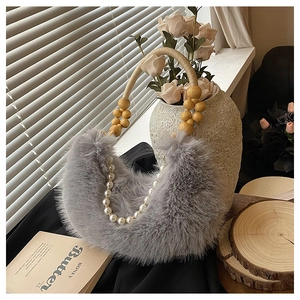 Détail d'un sac demi-lune en fausse fourrure grise avec chaîne perle et anse en bois