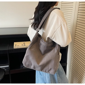 Detail of coffee brown large canvas crossbody bag with thick texture on shoulder