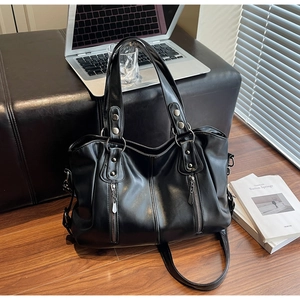 Détail du sac cabas en cuir noir avec clous argentés et bandoulière réglable