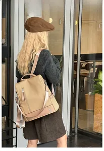 Detail of khaki woven backpack with leather trim and vertical zipper pocket