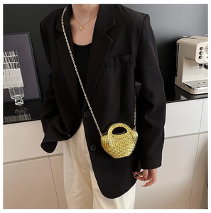 Dettaglio della mini borsa da sera dorata con strass scintillanti e tracolla a catena in metallo