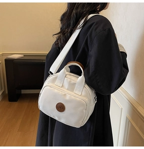White nylon crossbody bag with brown leather logo shown on model back view for size