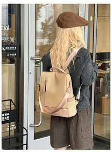 Detail of woven texture backpack with pink leather trim worn by model in a cafe setting