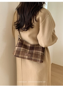 Detail of vintage brown plaid wool shoulder bag featuring an embossed leather brand tag