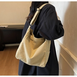 Close-up of beige canvas tote bag showing thick texture and adjustable wide strap