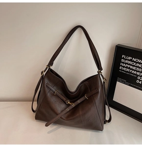 Detail of vintage dark brown tote bag with premium faux leather texture and gold hardware