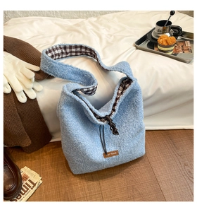 Detail view of light blue plush tote bag with drawstring closure and plaid lining