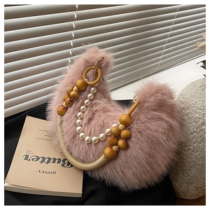 Détail du sac croissant en peluche rose avec une poignée en perles et bois décorée