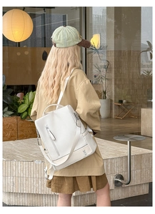 Detail of minimalist beige woven backpack showing cute rabbit print and adjustable straps
