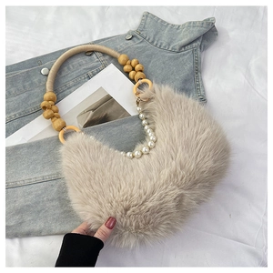 Détail du sac à bandoulière en peluche beige avec poignée en perles et bois