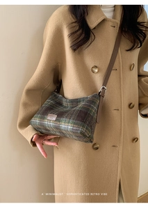 Close-up of green and brown plaid wool crossbody bag with leather fashion tag details