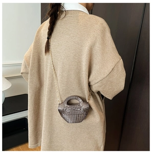 Dettaglio mini borsa intrecciata metallica con tracolla a catena dorata
