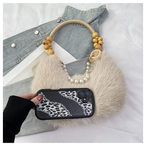 Détail d'un sac en fausse fourrure avec poignée en perles de bois et chaîne perlée