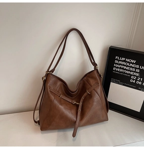 Detailed view of the dark brown leather hobo bag with matte gold hardware and soft texture
