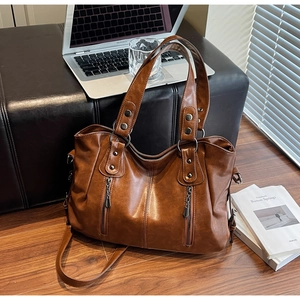 Vue détaillée du grand sac vintage marron avec double fermeture éclair et rivets