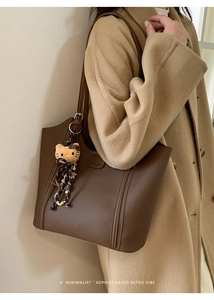 Détail du grand sac cabas marron foncé en cuir avec pendentif peluche à l'épaule