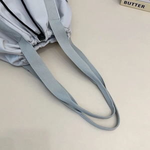 Close-up of lightweight nylon tote bag featuring durable handles and drawstring closure