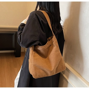 Close-up of caramel brown vintage canvas tote bag with wide strap for daily commute