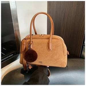 Macro detail of caramel vintage pillow bag with matte leather texture and Miu Miu logo