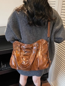 Brown punk rivet tote bag with lace-up detail and cross-body strap shown on model
