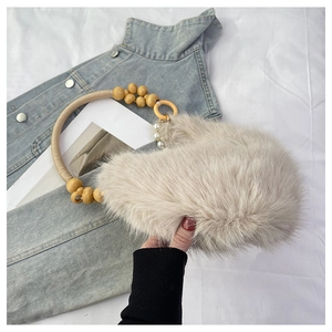 Détails d'un sac à main beige en fausse fourrure avec poignée en perles de bois