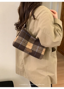 Detail showing vintage plaid pattern and fashion leather patch on a brown wool bag