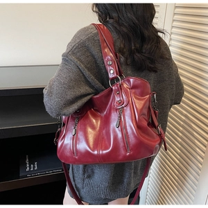 Détail macro du sac cabas rouge foncé avec fermetures éclair argentées et cuir souple