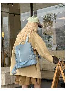Detailed view of grey blue leather backpack with woven texture and cute rabbit logo design